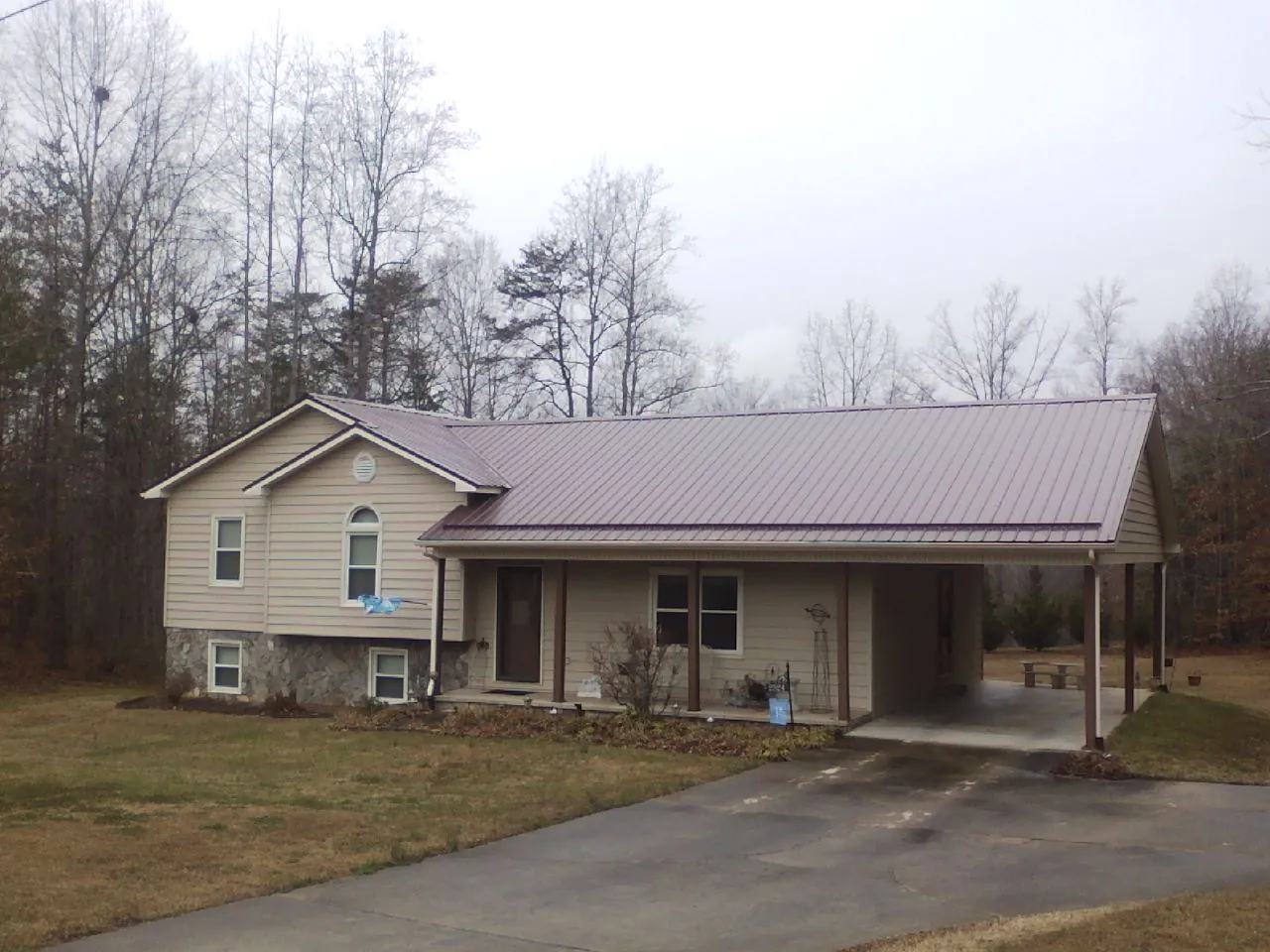 Burgundy metal roof on a tan split level home with an attached carport in Glen Gardner