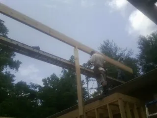 Carpenter setting a ridge beam over a new addition frame — Ice Dam Removal by Roofing Brothers in Glen Gardner