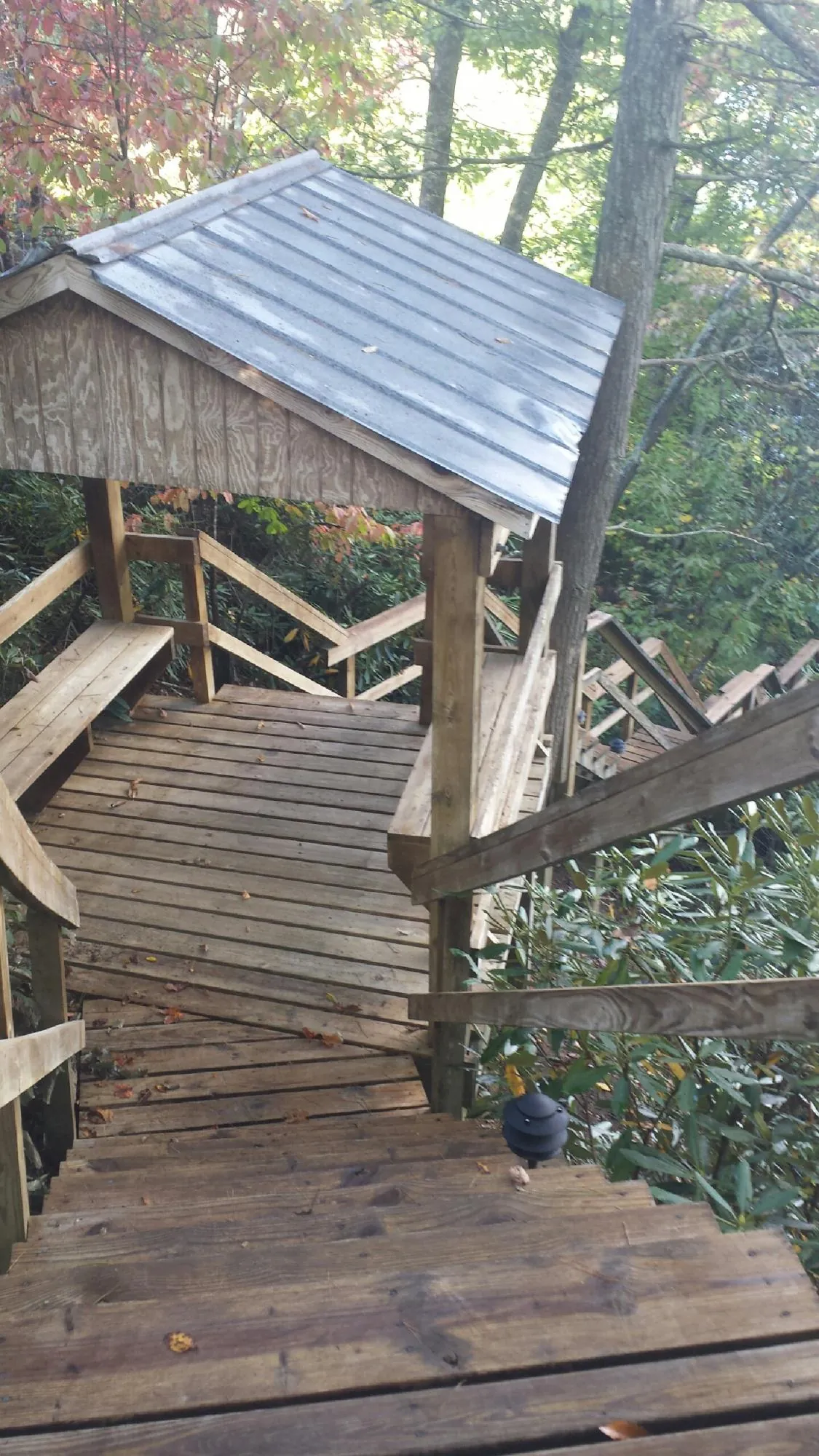 Metal roofed shelter over wooden steps on a wooded walkway — Skylight Repair & Installation work by our crew in Glen Gardner